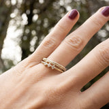 Hand with Melanie Pigeaud princess diamond ring in 14k gold and Melanie Pigeaud rusty stacking ring in 14k gold