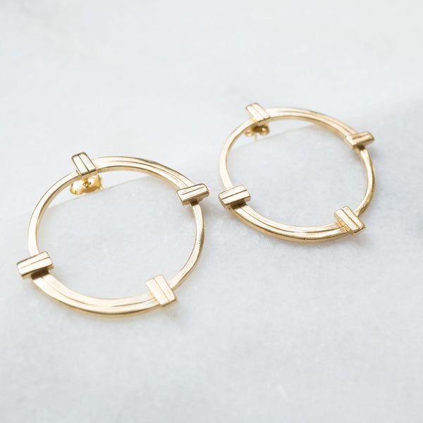 Melanie Pigeaud imperfect balance big earrings in 14k gold presented on marble