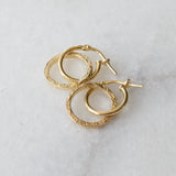 Melanie Pigeaud circle of empower earrings in 14k gold presented on marble