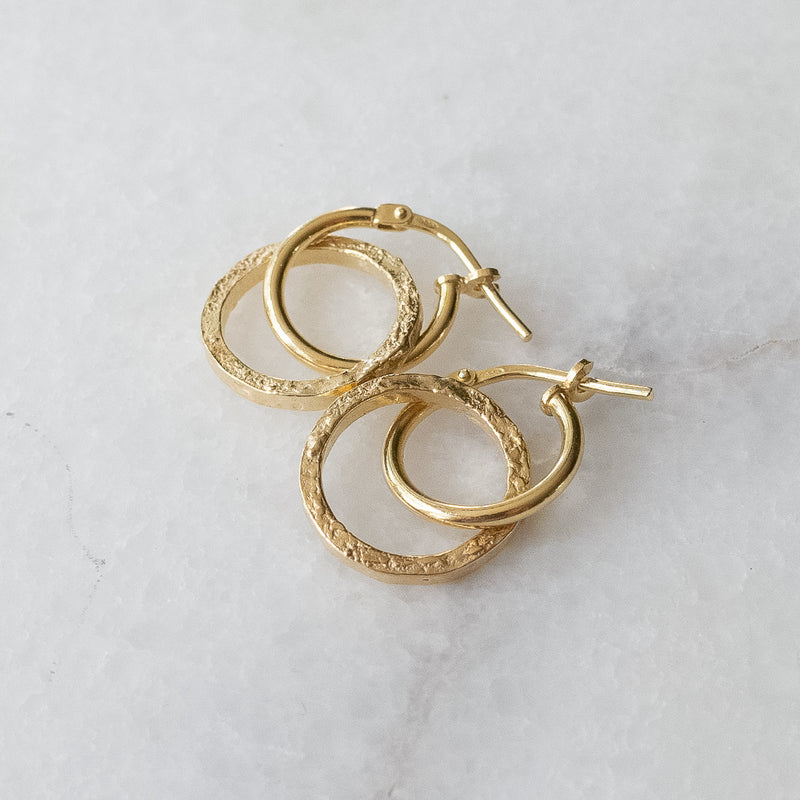 Melanie Pigeaud circle of empower earrings in 14k gold presented on marble