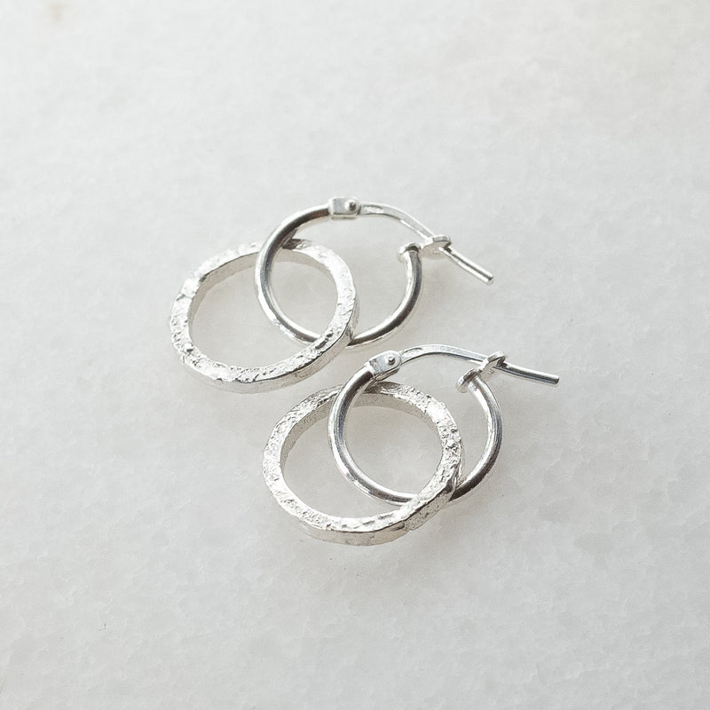 Melanie Pigeaud circle of empower earrings in sterling silver presented on marble