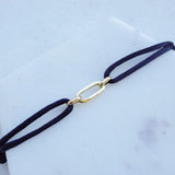 MP together bracelet black by Melanie Pigeaud presented on marble stone.