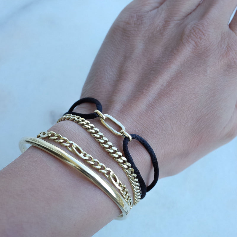 Wrist with MP together bracelet black 14k gold by Melanie Pigeaud and 3 other bracelets