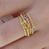 Stack of Melanie Pigeaud rings, including Melanie Pigeaud amethyst ring in 9k gold