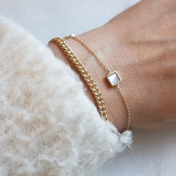 Wrist with twogold bracelets by Melanie Pigeaud, including the Gourmet round chain.
