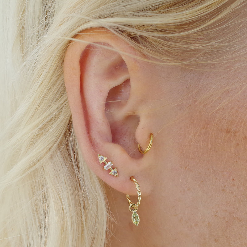 Ear with Melanie Pigeaud fierce stud earring in 9k gold and Melanie Pigeaud rope earring with peridot stone in 9k gold