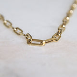 The Drawn chain bracelet 14k gold by Melanie Pigeaud presented on a marble stone.zoomed in on detail. 