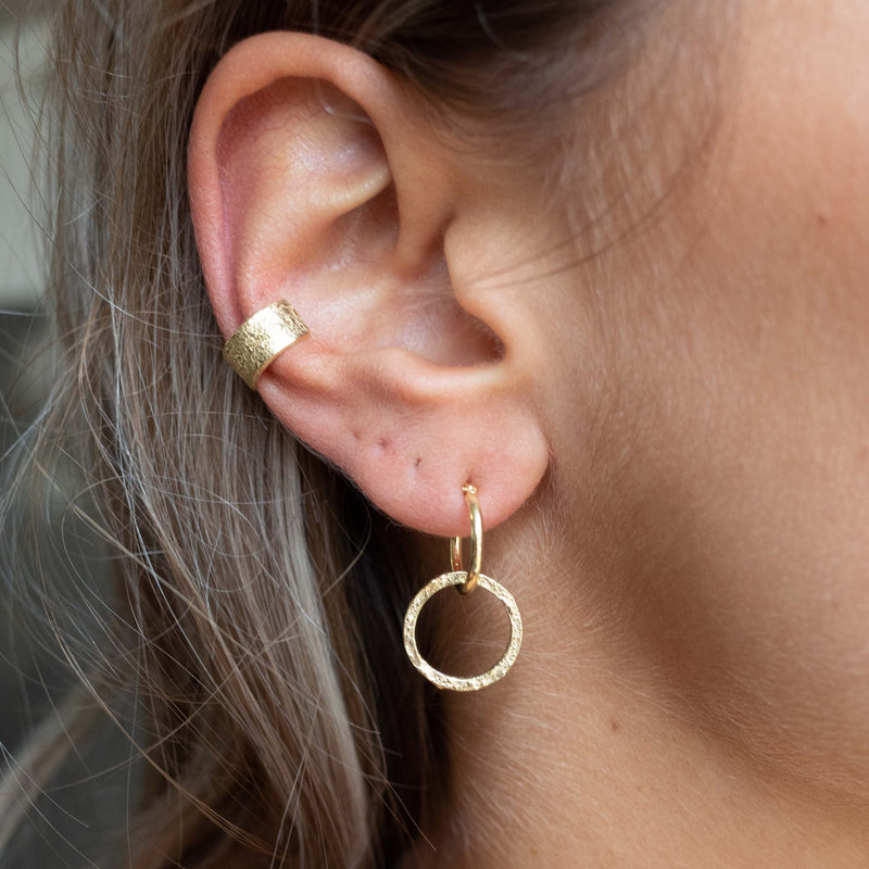 Ear with Melanie Pigeaud earcuff in 14k gold and circle of empower earring