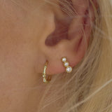 Ear with Melanie Pigeaud zirconia round dot earring in 9k gold and Melanie Pigeaud bamboo hoop earring in 9k gold