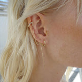 Ear with Melanie Pigeaud fierce ear cuff with zirconia's and chain in 9k gold and Melanie Pigeaud bamboo hoops in 9k gold