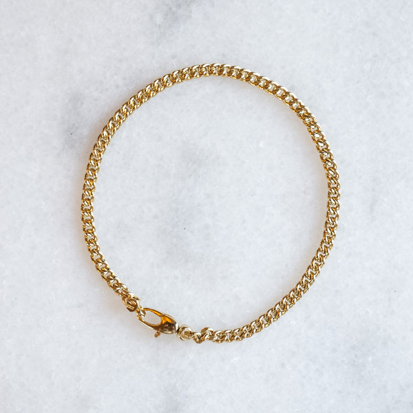 Gourmet round chain 3 mm 14k gold by Melanie Pigeaud presented on marble stone.