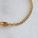 Gourmet round chain 3 mm 14k gold by Melanie Pigeaud presented on marble stone. zoomed in on detail