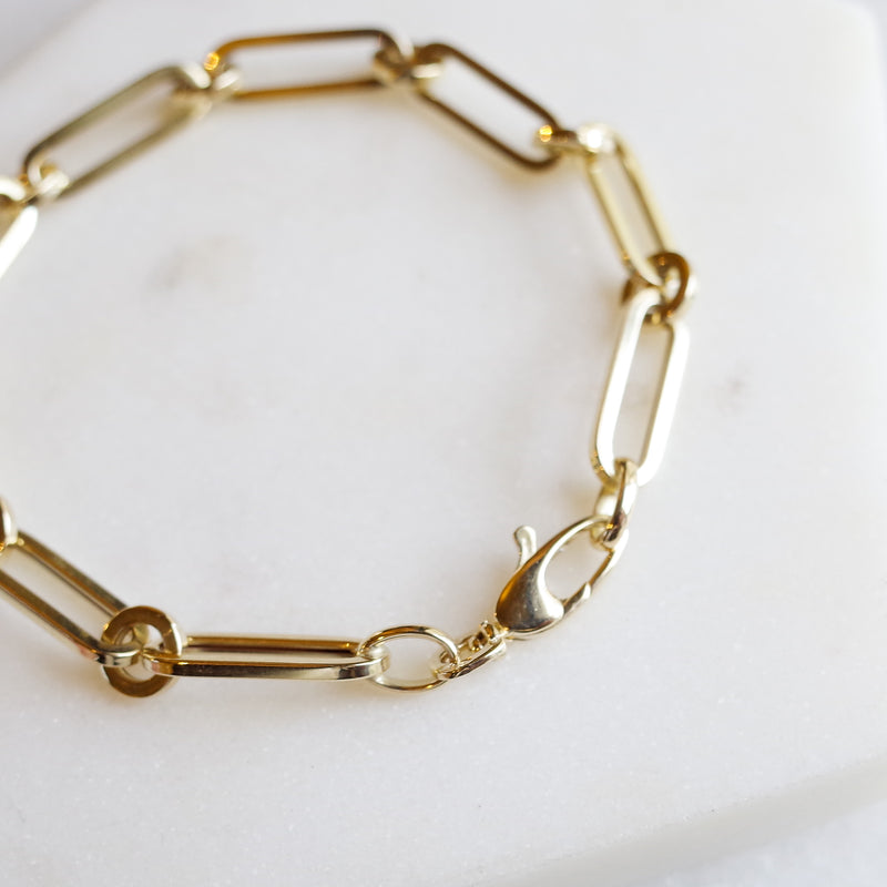 Inter drawn chain bracelet 14k gold by Melanie Pigeaud presented on marble stone. zoomed in on detail