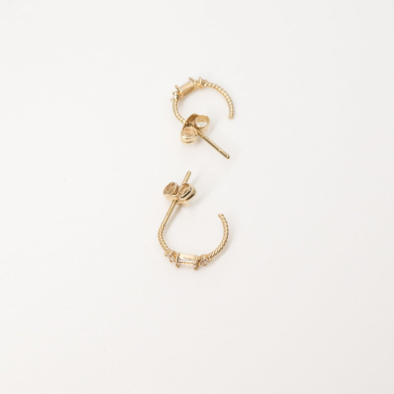 Melanie Pigeaud zirconia hoops in 9k in gold lying down