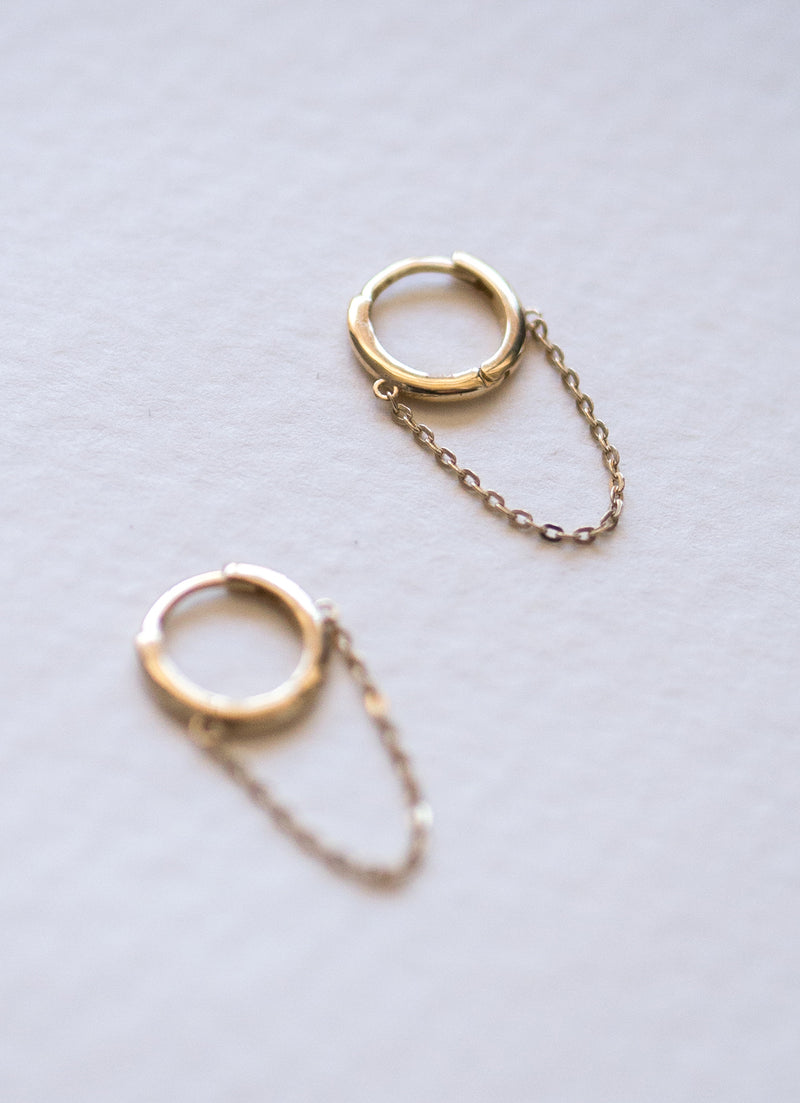 Close up of set of Melanie Pigeaud chain hoops earrings in 9k gold