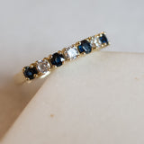 Melanie Pigeaud sapphire zirconia row ring in 14k gold presented on marble